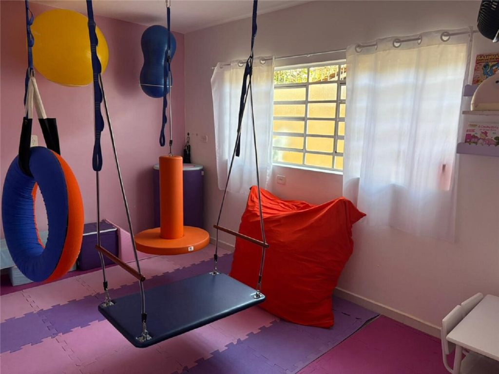Sala com balanços, boias suspensas e materiais para movimento